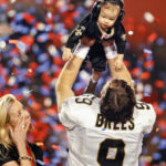 Drew Brees raises his son overhead after defeating the Indianapolis Colts in Super Bowl XLIV