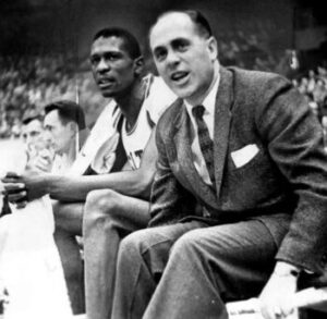Boston Celtics center Bill Russell sitting on the bench next to head coach Red Auerbach on December 26, 1956.