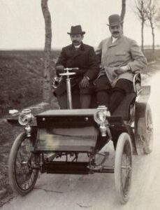 Georges Bouton and Jules-Albert de Dion in 1899 in one of their motorized vehicles.