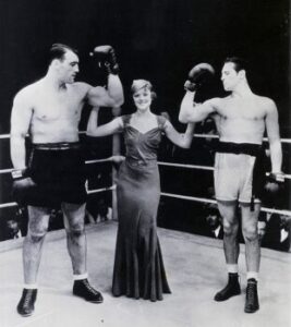 (Original Caption) 1933-Primo Carnera and Max Baer in "movie" ring with Myrna Loy.