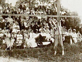 Film still from the American film Casey at the Bat (1916) with an injured Casey (DeWolf Hopper) watching his Mudville team lose Game 2 to Frogtown; the still's caption in cited publication reads "The disabled Casey looks on"; scene filmed in Lankershim, California, between the last week in April and early May 1916; crowd in the background were residents of Lankershim who attended the three baseball games filmed during production, performing as "free" extras. from the Triangle Film Corporation