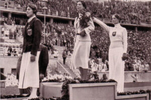 Elek Ilona a berlini (1936) olimpia bajnoka az eredményhirdetésen, kezében az ajándék tölgyfacsemetével. 1: Elek Ilona (HUN) 2: Helene Mayer (GER) 3:Ellen Müller-Preis (AUT)